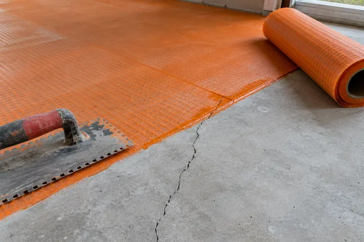 Crack isolation membrane over a slab crack before tile
